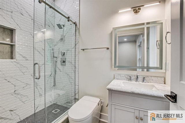 bathroom featuring toilet, vanity, and walk in shower