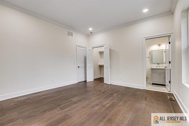 unfurnished bedroom featuring ensuite bathroom, crown molding, and dark hardwood / wood-style floors