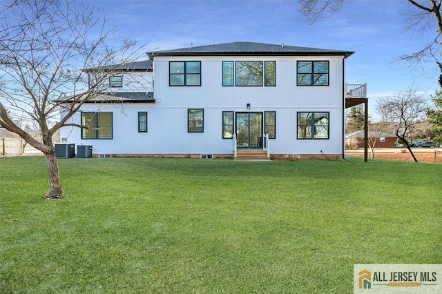 back of house featuring central AC unit and a lawn