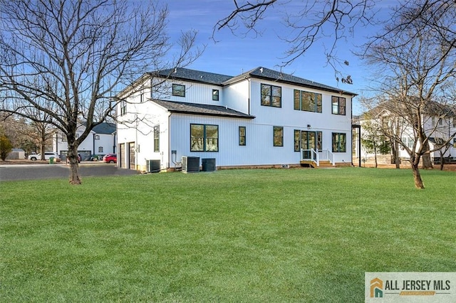 rear view of property with a yard and central air condition unit