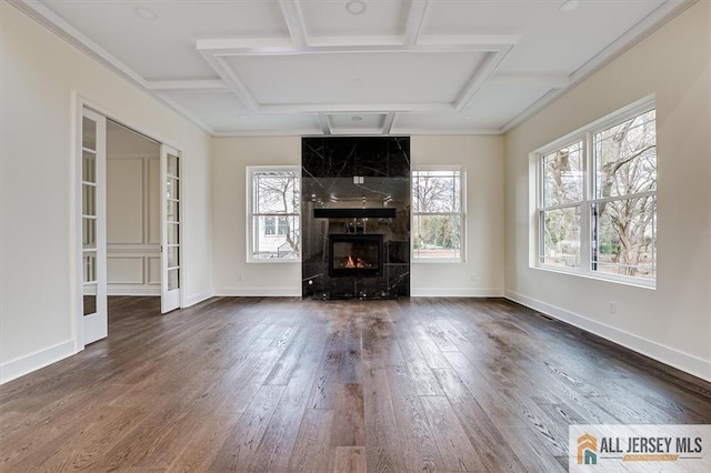 unfurnished living room featuring coffered ceiling, a high end fireplace, dark wood-type flooring, and beam ceiling