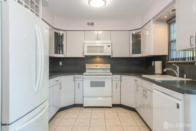 kitchen featuring light tile patterned flooring, white appliances, backsplash, and white cabinets