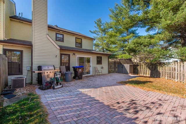 back of property with a patio area and a storage shed