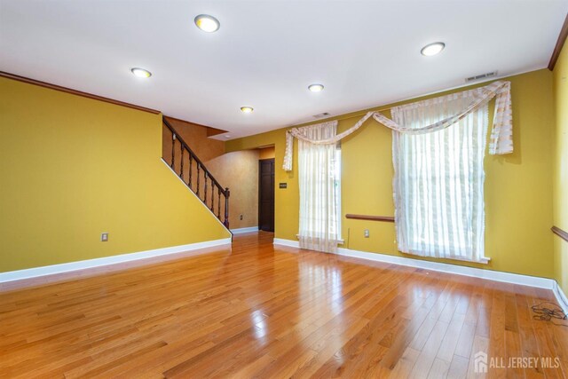 unfurnished room featuring ornamental molding and light hardwood / wood-style flooring