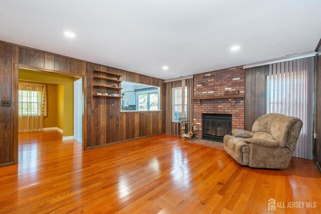 unfurnished living room featuring wood walls, a healthy amount of sunlight, and a fireplace