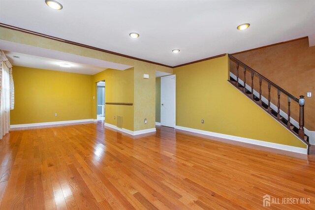 unfurnished living room featuring light hardwood / wood-style flooring and ornamental molding