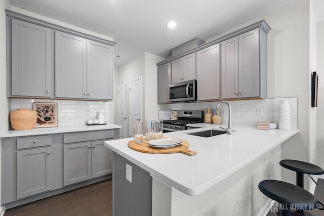 1305 Parker Blvd, West Windsor, NJ 08550 - kitchen with appliances with stainless steel finishes, gray cabinets, a sink, a breakfast bar area, and recessed lighting