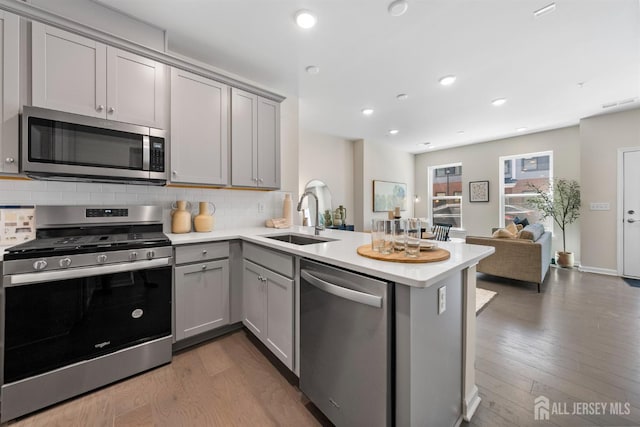 1305 Parker Blvd, West Windsor, NJ 08550 - kitchen with stainless steel appliances, gray cabinets, a sink, a peninsula, and tasteful backsplash
