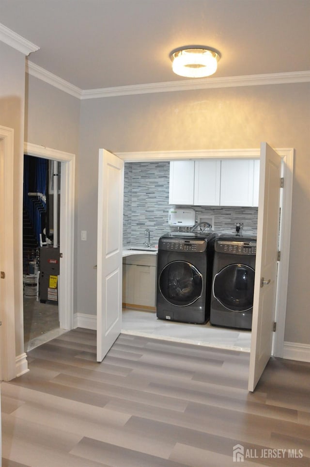 260 Church Ln, North Brunswick, NJ 08902 - washroom with separate washer and dryer, cabinet space, light wood finished floors, crown molding, and baseboards