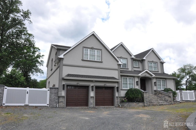 260 Church Ln, North Brunswick, NJ 08902 - view of front of home with a gate, stucco siding, driveway, an attached garage, and stone siding