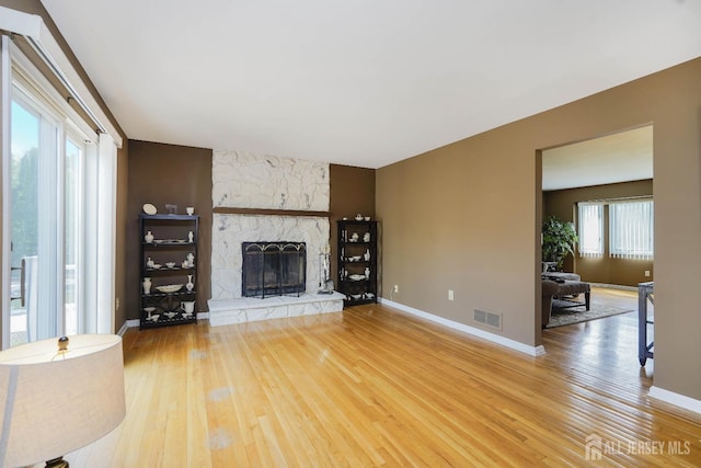 415 Spotswood Englishtown Rd, Monroe, NJ 08831 - unfurnished living room featuring wood-type flooring, a stone fireplace, and baseboards