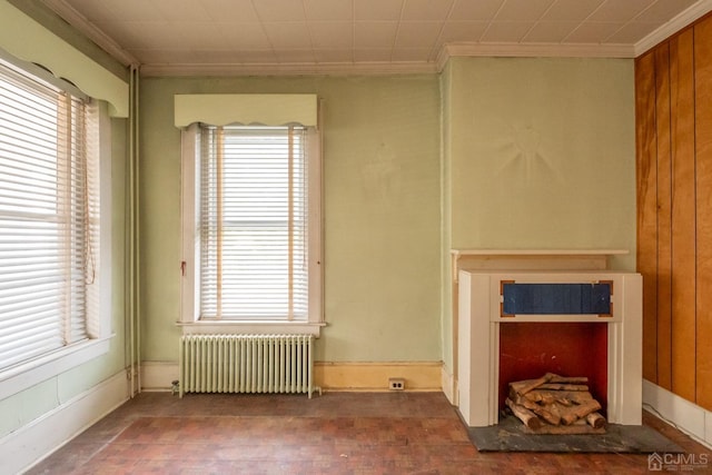 unfurnished living room with radiator heating unit and crown molding