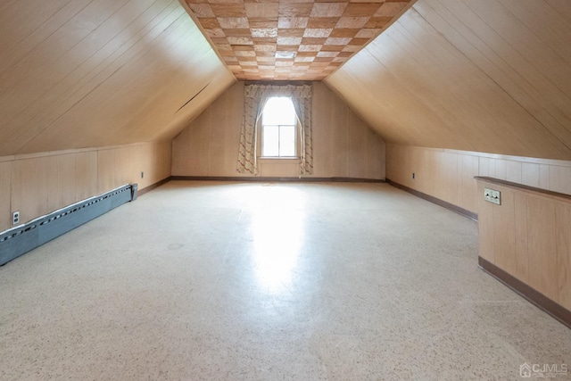 additional living space featuring vaulted ceiling and a baseboard heating unit