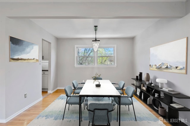 dining area with baseboards and light wood-style flooring