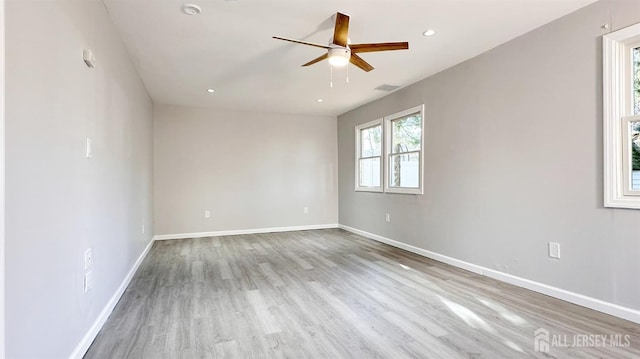 empty room with ceiling fan and light hardwood / wood-style floors