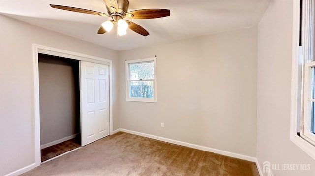 unfurnished bedroom with ceiling fan, carpet flooring, and a closet