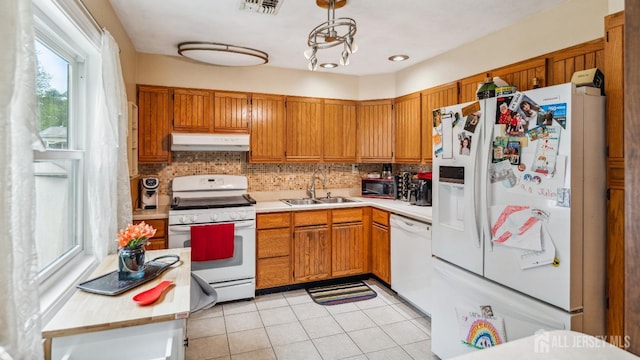 587 Malboro Rd, Old Bridge, NJ 08857 - kitchen featuring white appliances, under cabinet range hood, light countertops, decorative backsplash, and brown cabinetry