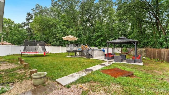 587 Malboro Rd, Old Bridge, NJ 08857 - fenced backyard with a trampoline, an outdoor living space, a deck, a gazebo, and a patio