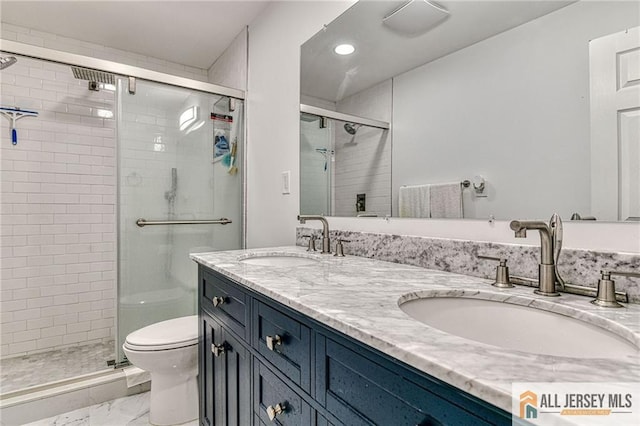 bathroom featuring double vanity, a shower stall, toilet, and a sink