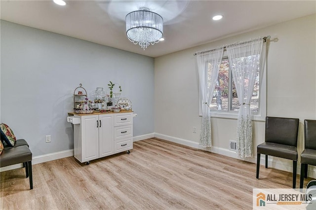 interior space featuring recessed lighting, baseboards, light wood finished floors, and an inviting chandelier