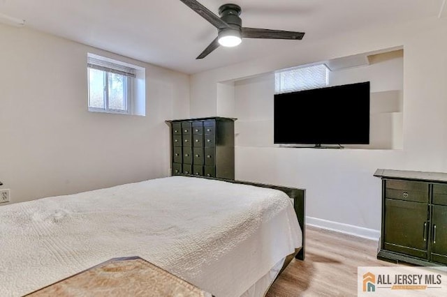 bedroom with ceiling fan, wood finished floors, and baseboards