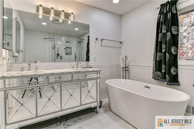 full bath with double vanity, a stall shower, a soaking tub, marble finish floor, and a sink