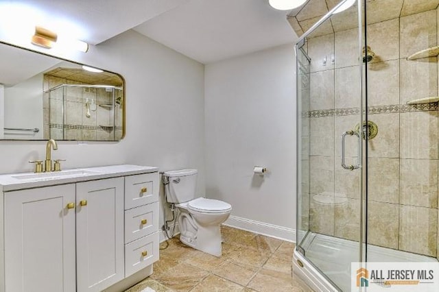 full bathroom with toilet, a stall shower, vanity, and baseboards