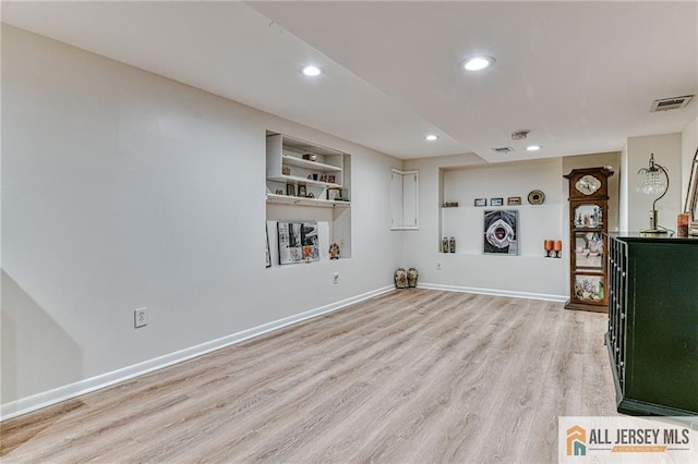 unfurnished living room with light wood-type flooring, visible vents, baseboards, and recessed lighting