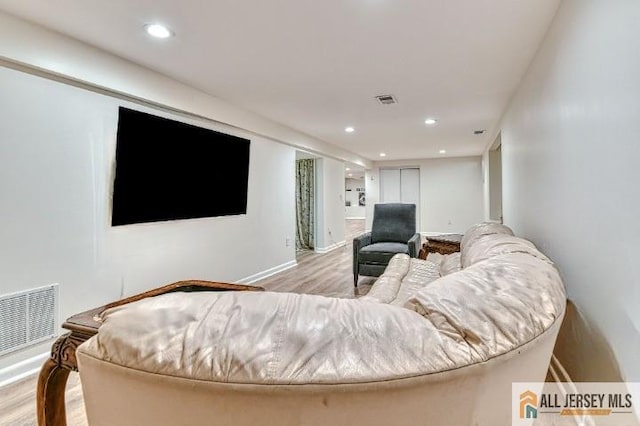 living area featuring baseboards, wood finished floors, visible vents, and recessed lighting