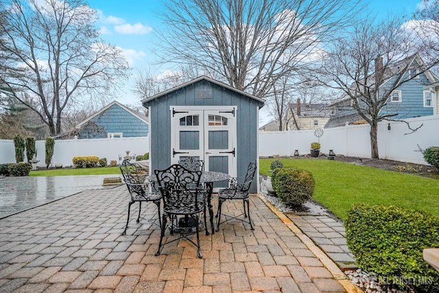 view of patio / terrace with a storage unit, an outbuilding, and a fenced backyard