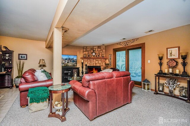 living room with visible vents and a stone fireplace