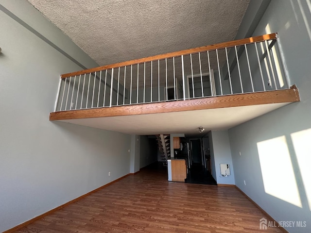 unfurnished living room featuring stairs, baseboards, and dark wood finished floors