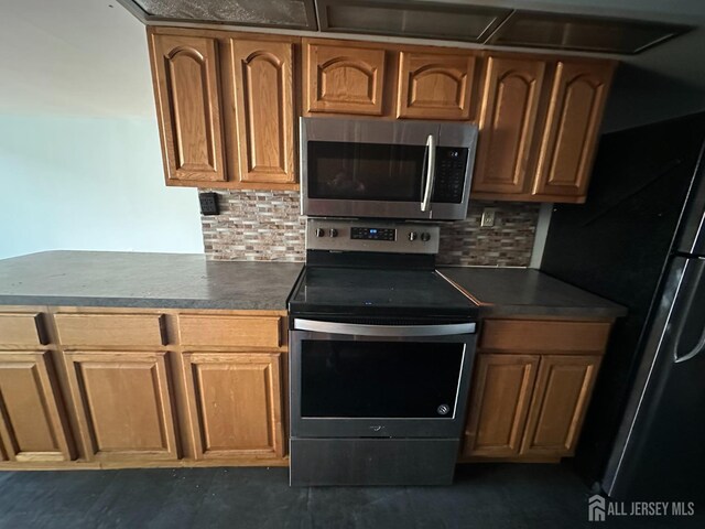 kitchen with stainless steel appliances, kitchen peninsula, and decorative backsplash