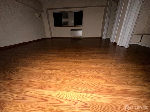 spare room featuring baseboards and wood finished floors