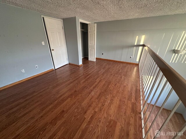 interior space with dark wood-type flooring and a textured ceiling