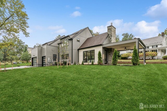 rear view of house featuring ceiling fan and a yard