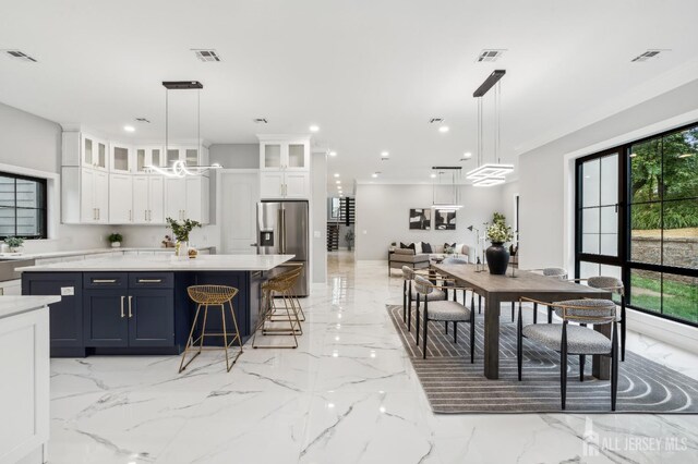 kitchen with plenty of natural light, white cabinetry, and hanging light fixtures