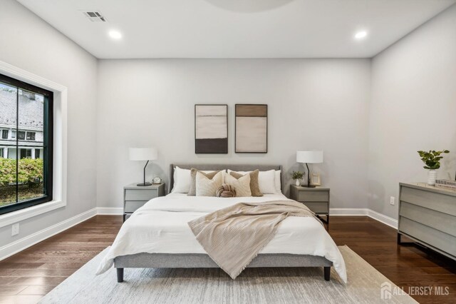 bedroom featuring dark hardwood / wood-style flooring and multiple windows