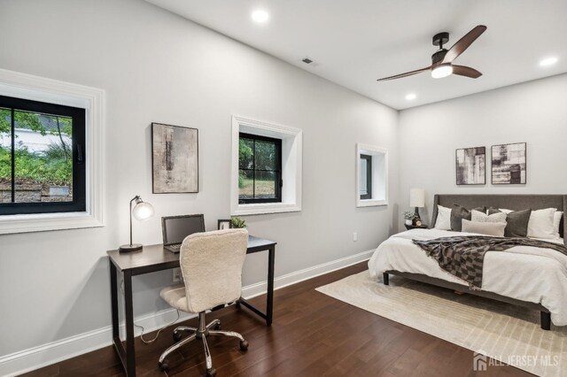 bedroom with dark hardwood / wood-style flooring, multiple windows, and ceiling fan