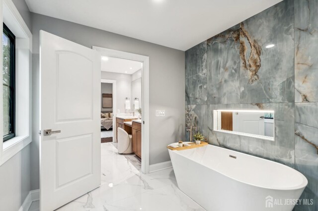 bathroom with a washtub and tile walls