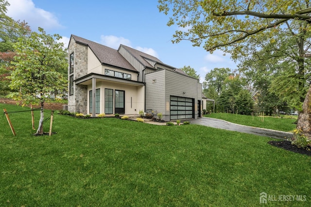 back of house with a yard and a garage