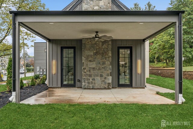 doorway to property with ceiling fan, a patio area, and a lawn