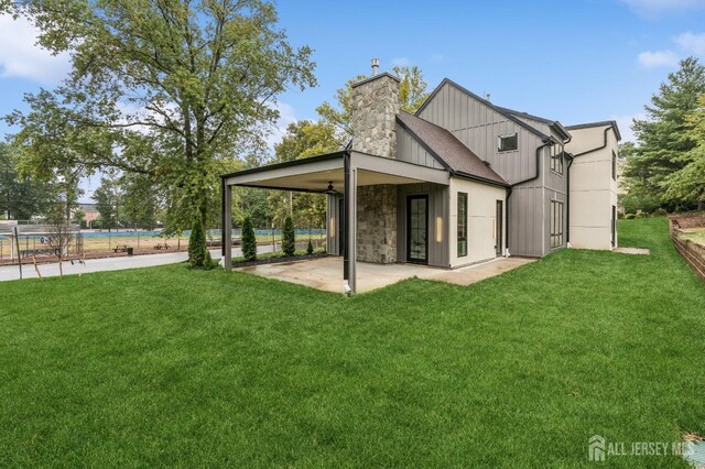 rear view of property with a yard, ceiling fan, and a patio area