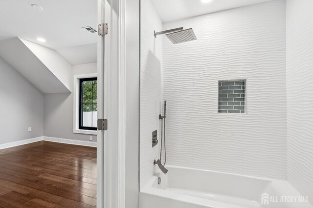 bathroom featuring wood-type flooring and tiled shower / bath combo