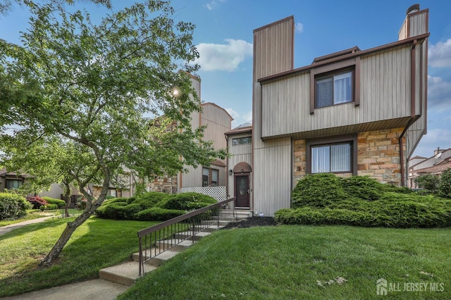 160 Goldmine Ln, Old Bridge, NJ 08857 - townhome / multi-family property featuring stone siding, a front yard, and a chimney