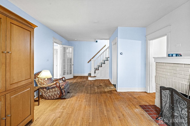 110 N 5th Ave N, Highland Park, NJ 08904 - entrance foyer featuring wood-type flooring, stairs, a brick fireplace, and baseboards