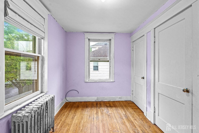 110 N 5th Ave N, Highland Park, NJ 08904 - unfurnished bedroom with radiator heating unit, light wood-type flooring, and baseboards