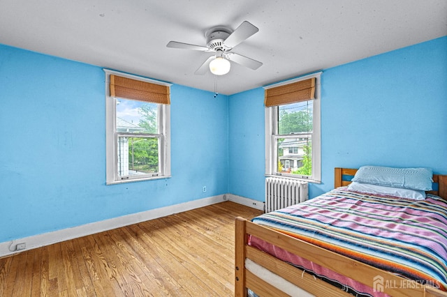 110 N 5th Ave N, Highland Park, NJ 08904 - bedroom featuring radiator heating unit, baseboards, wood finished floors, and a ceiling fan