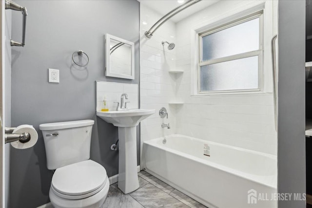 bathroom with toilet and tiled shower / bath combo