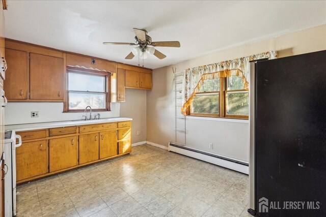 kitchen featuring baseboard heating, ceiling fan, and sink